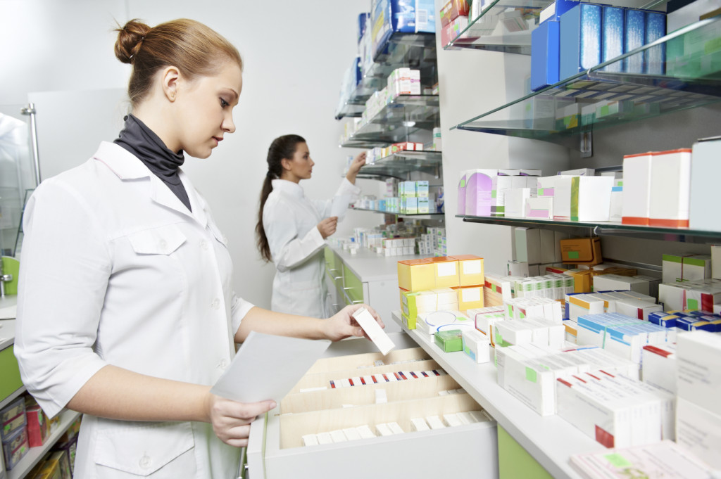 two pharmacist chemist women working in pharmacy drugstore