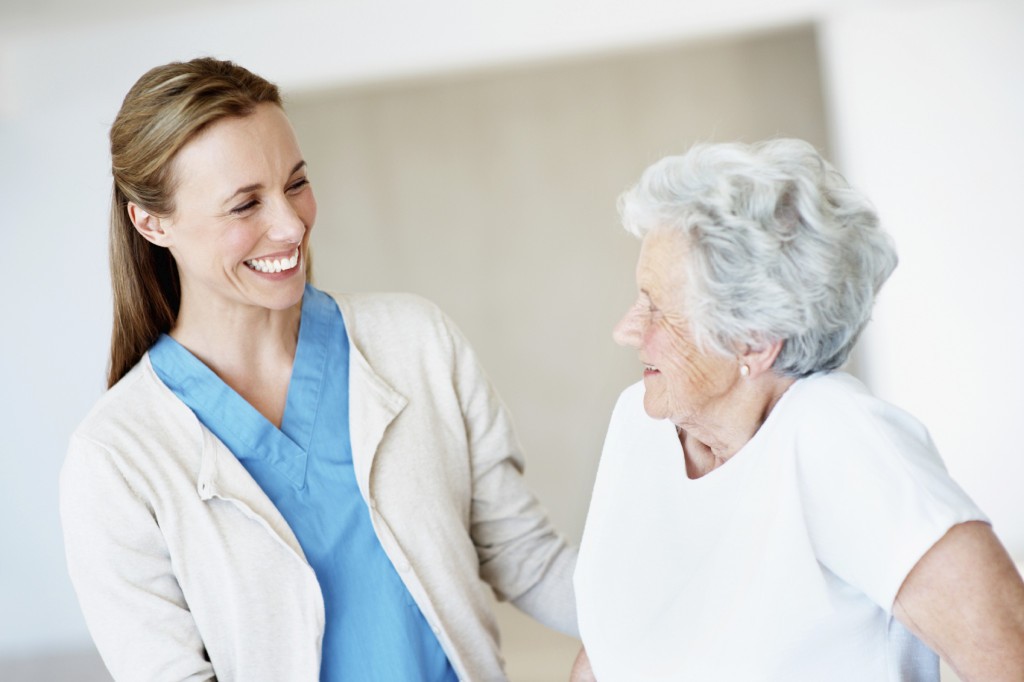 A friendly nurse smiling at an elderly lady